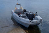 White boat with 'CARGU' branding on a calm body of water near a shoreline.