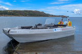Boat named 'CARDHU' on a dock with a scenic background